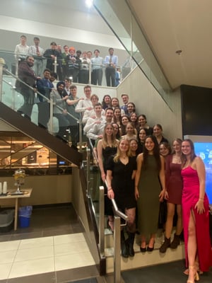 Image of competitors at the event: people gathered on stairs in formal dress